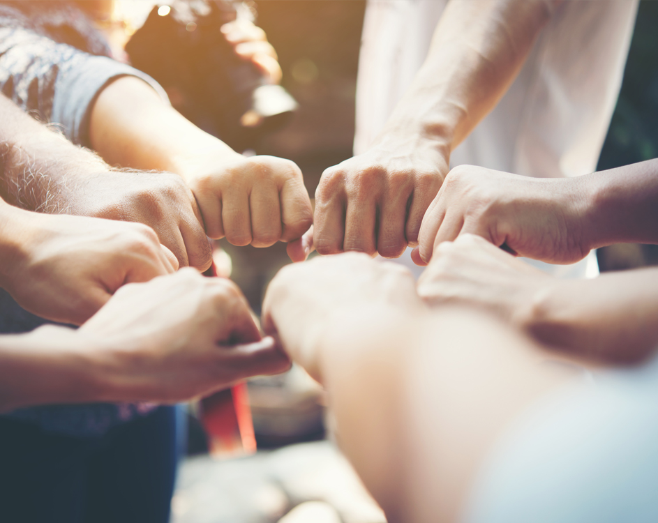 Colleagues joining hands in a team huddle